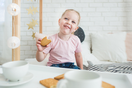 Cute little girl drinks tea with her teddy bear.の写真素材
