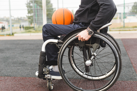 Young man in a wheelchair playing basketball.の写真素材