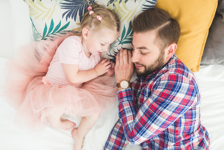 Father and daughter sleeping together in bed.の写真素材