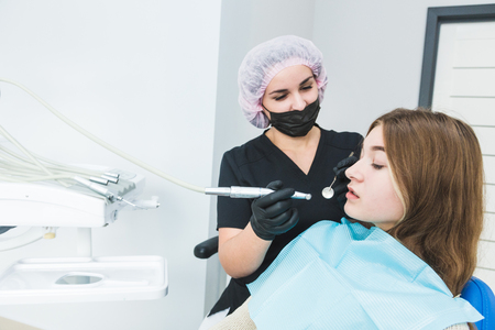 Dental clinic. Reception, examination of the patient. Teeth care. Dentist curing a girl patientの写真素材