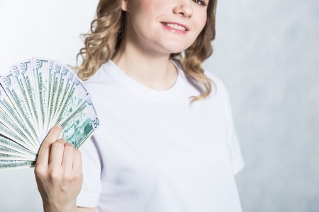 Happy young smiling woman hold us dollar money in hand over white background.