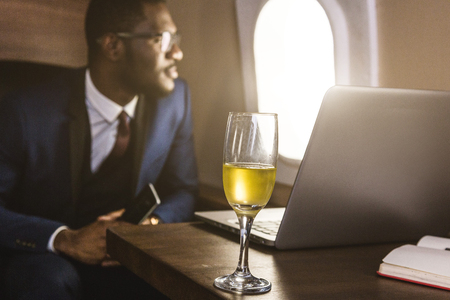 Attractive and successful African American businessman with glasses working on a laptop while...