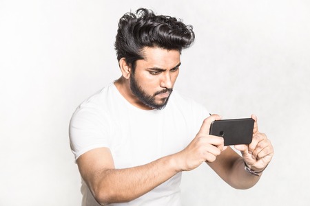 Young handsome man taking pictures on smartphone.