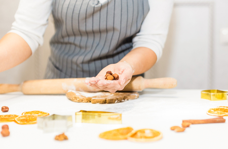 Young pretty woman prepares the dough and bakes gingerbread and cookies in the kitchen. Merry Christmas and Happy New Year.の写真素材