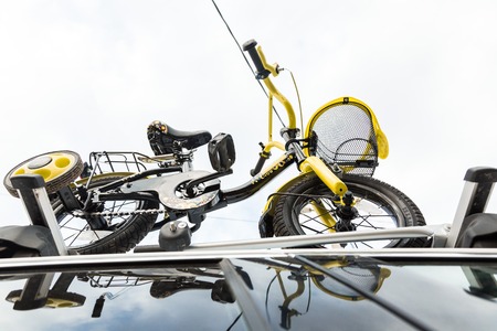 Bicycle transport - a childrens bicycle on the roof of a car against the sky in a special mount for...