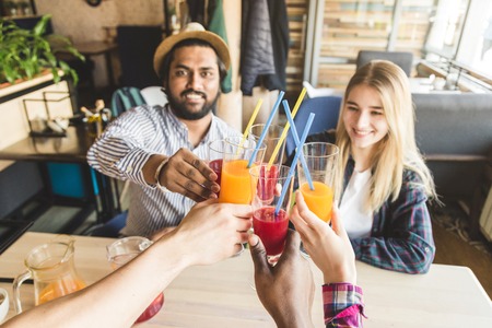 A company of young people having fun, drinking drinks, cocktails, juices in a cafe. Meeting best friendsの写真素材