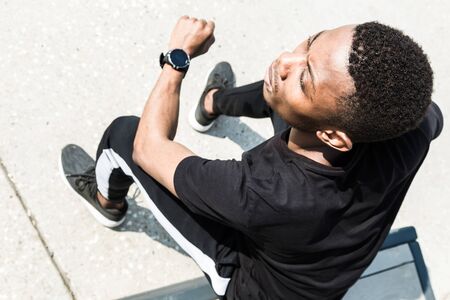 Athletic young afroamerican man running on the promenade. Black Male runner sprinting outdoors....