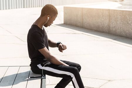 Athletic young afroamerican runner doing warm up on the promenade. Black Male running on outdoors. Healthy lifestyle concept.の写真素材