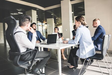 A team of young businessmen working and communicating together in an office. Corporate businessteam...