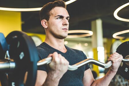 Man Working out with barbell weights at the gym.Fitness men exercising are lifting dumbbells....