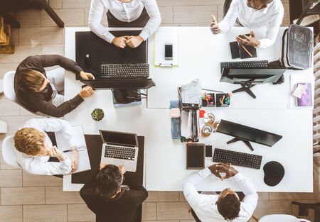 A team of young businessmen working and communicating together in an office. Corporate businessteam and manager in a meetingの写真素材