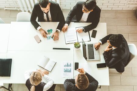 A team of young businessmen working and communicating together in an office. Corporate businessteam and manager in a meetingの写真素材