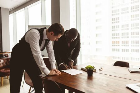 Dialogue of two businessmen in suits working and communicating together in an office. Corporate businessteam and manager in a meetingの写真素材