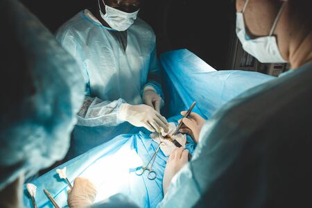 The senior surgeon in the operating room, where the patient is waiting for him, and he begins the operation. Real Modern Hospital with Authentic Equipmentの写真素材