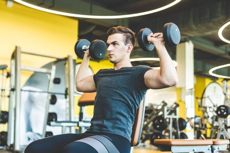 Working out with dumbbell weights at the gym.Fitness men exercising are lifting dumbbells. Fitness...