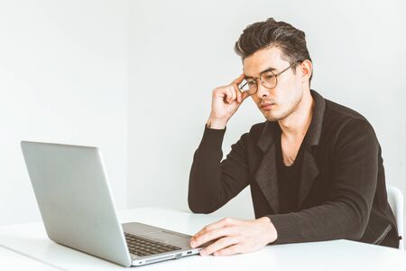 Young businessman working in the office at the laptop