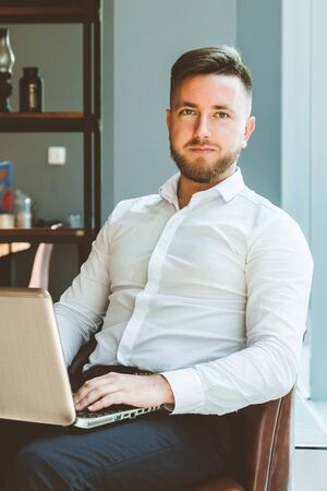 portrait of a young businessman with laptop in the interior