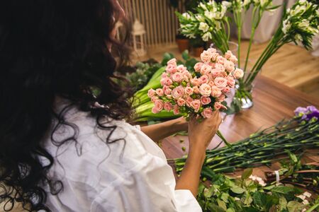 Attractive young woman florist is working in a flower shop.の写真素材