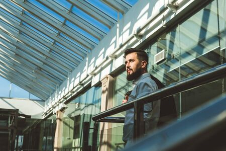 Portrait of a businessman in suit are standing on the background of glass offices.