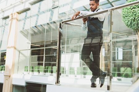 Portrait of a businessman in suit are standing on the background of glass offices.