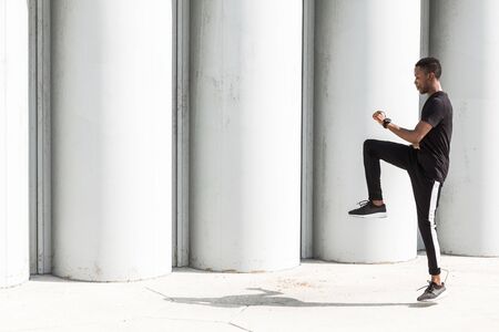 Athletic young afroamerican man running on the promenade. Black Male runner sprinting outdoors. Healthy lifestyle concept.の写真素材