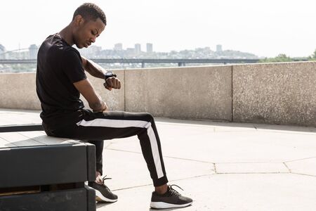Athletic young afroamerican man running on the promenade. Black Male runner sprinting outdoors. Healthy lifestyle concept.の写真素材