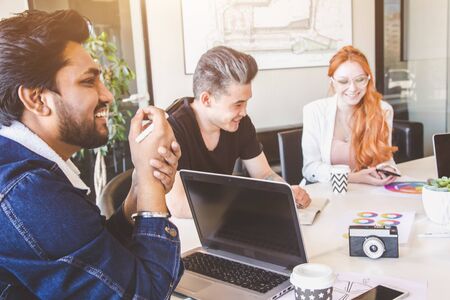 Group of multi ethnic executives discussing during a meeting. Business man and woman sitting around...