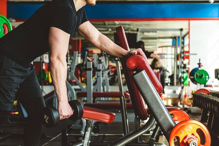 Training with dumbbells in the gym. Strength exercises for endurance.の写真素材