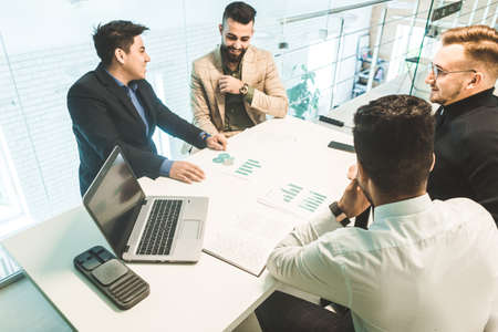 A team of young businessmen working and communicating together in an office. Corporate businessteam...