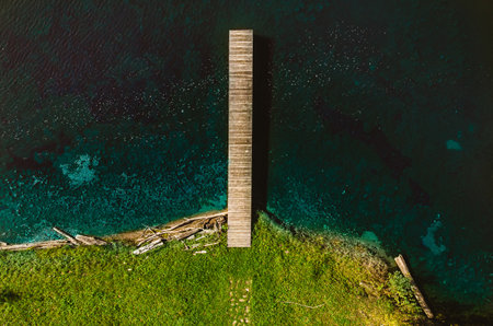 Top view of an old wooden empty pier on a beautiful blue-green lakeの写真素材