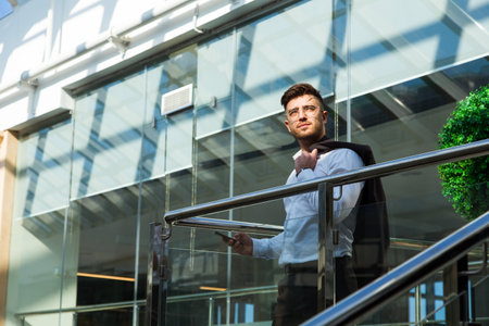 Portrait of a businessman in suit are standing on the background of glass offices.の写真素材