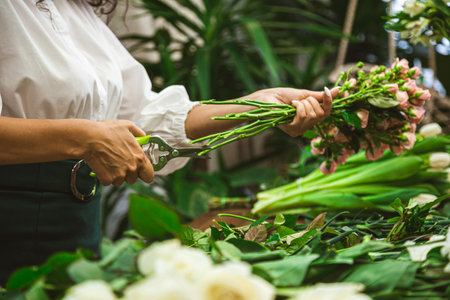 Attractive young woman florist is working in a flower shop.