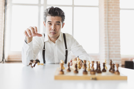 planning strategy with chess figures on an old wooden table. Businessman holding and throwing chess to . Setup objectives and target for business investment concept.の写真素材