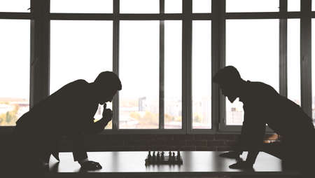 two male businessmen, rivals are playing chess. Strategy and rivalry.