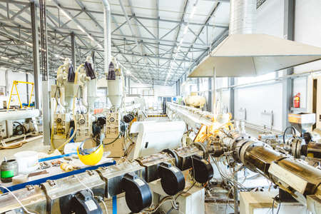Workshop with extruders for producing plastic pipes. High speed extrusion line of water suppply and...