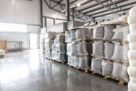 Spacious warehouse in a factory with special racks and shelves and products placed on them.の写真素材