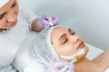 Facial skin care and protection. A young woman at a beauticians appointment. The procedure for applying a mask on the faceの写真素材