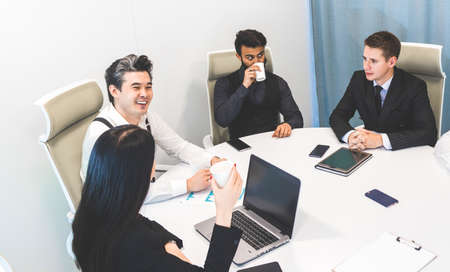 top view Group of young business people working and communicating while sitting at the office desk...