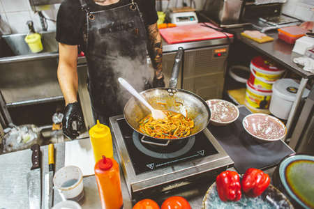street food. fried noodles in a wok with chicken and shrimp on the wok.の写真素材