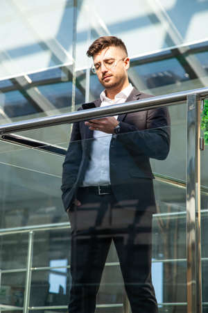 Portrait of a businessman in suit are standing on the background of glass offices.の写真素材