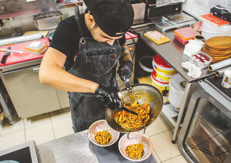 street food. fried noodles in a wok with chicken and shrimp on the wok.