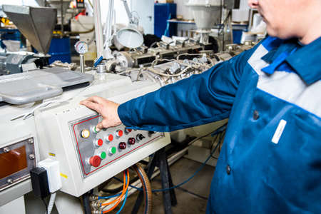 Hand pressing on green button of the machine in the factoryの写真素材