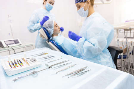 Dentistry concept. Professional dental services and modern equipment without pain. Doctor with an assistant treating the patients teethの写真素材