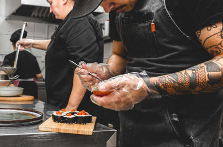 male cooks preparing sushi in the restaurant kitchen.の写真素材