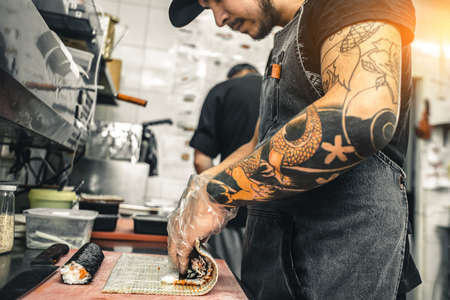 male cooks preparing sushi in the restaurant kitchen.の写真素材