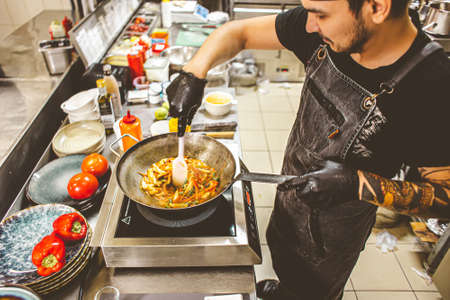 street food. fried noodles in a wok with chicken and shrimp on the wok.の写真素材
