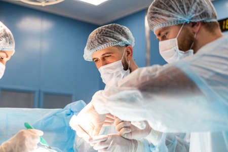 An international team of doctors performs a complex surgical operation on a patient under...