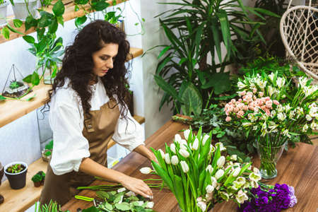 Attractive young woman florist is working in a flower shop.の写真素材