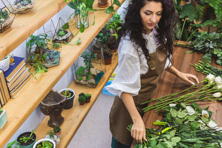 Attractive young woman florist is working in a flower shop.の写真素材