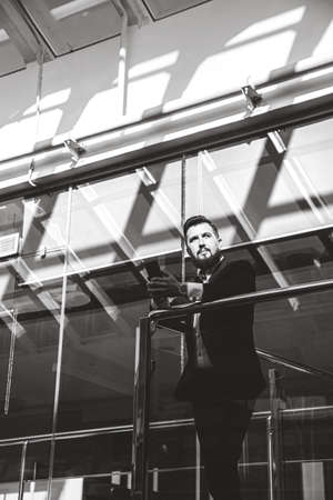 Portrait of a businessman in suit are standing on the background of glass offices.の写真素材